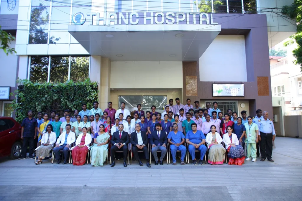 THANC Hospital team in front of the hospital building